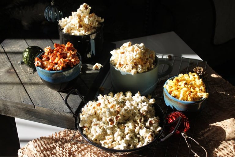Assorted bowls of gourmet popcorn in a rustic, cozy setting, perfect for a snack lover.